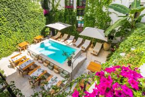 - une vue sur la piscine bordée de chaises et de parasols dans l'établissement Casa Nostra Luxury Suites & Spa, à Palerme