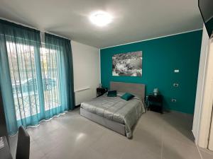 - une chambre avec un lit et un mur bleu dans l'établissement Lotelito Apartment, à Fisciano