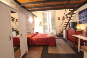 Un dormitorio con una cama roja y una escalera en Amenano Apartments, en Catania