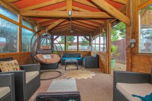 a screened in porch with a couch and a swing at Station Signature Apartment near Lanark in Carstairs