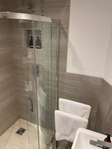 a shower with a glass door next to a sink at Staycation York at Cocoa Suites in York