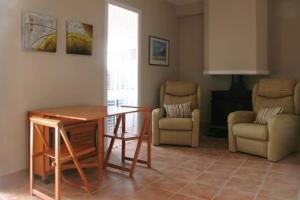 a living room with a table and a chair at Ca la tieta Quima in Guiamets