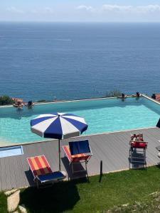 a swimming pool with two chairs and an umbrella at Villa Bice in Bergeggi