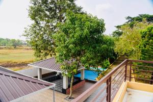 een uitzicht vanaf het balkon van een huis met een boom bij Charming “Nature’s Craft Homestay Retreat” in Manipala
