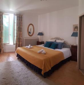 a bedroom with a large bed with blue pillows at Belle maison de charme in Lussac +25 photos