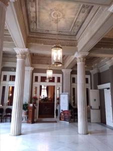a lobby with columns and a ceiling with a chandelier at Lovely,central, spacious 2-bedrooms apartment in Piraeus