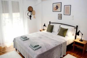 a white bedroom with a large bed with green pillows at Lovely,central, spacious 2-bedrooms apartment in Piraeus +47 photos