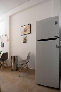 a white refrigerator in a room with a table and chairs at Lovely,central, spacious 2-bedrooms apartment in Piraeus