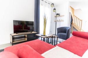 sala de estar con sofá rojo y TV en La Maison Vermeil - Grande maison moderne à Lavaur, en Lavaur