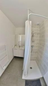 baño blanco con ducha y lavamanos en La Maison Vermeil - Grande maison moderne à Lavaur, en Lavaur