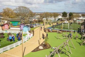 a park with a playground with people in it at Ormesby 8, Haven Holiday Park, Caister - Four Bedroom, sleeps 8, pets welcome - 2 minutes from the beach! in Great Yarmouth