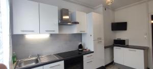 a kitchen with white cabinets and a sink at F2, entièrement neuf, 65m² in Montceau-les-Mines