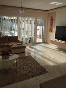 a living room with a couch and a tv at Sarkcsillag teljes családiház- Star Complete Family House in Szeged