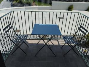 - Balcón con mesa azul y 2 sillas en Lotelito Apartment en Fisciano
