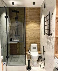 a bathroom with a shower and a toilet and a sink at Alan Apartments in Almaty