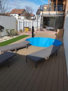 a swimming pool with two benches on a deck at Sarkcsillag teljes családiház- Star Complete Family House in Szeged