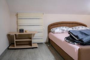 a small bedroom with a bed and a night stand at Big Lale UR in Bijeljina