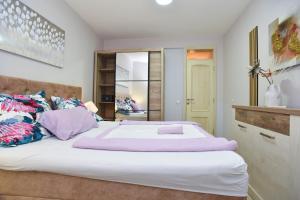 1 dormitorio con 1 cama blanca grande con almohadas moradas en Apartment Vidar, en Budva