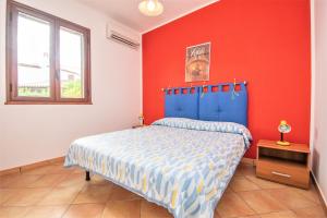 a bedroom with a blue bed and a red wall at Sole Mare Deluxe in Campofelice di Roccella +34 photos