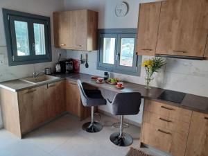 a kitchen with a counter and two chairs in it at Nama Seaview Kokkari in Kokkari