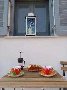 a table with plates of food and cups on it at Nama Seaview Kokkari in Kokkari +25 photos