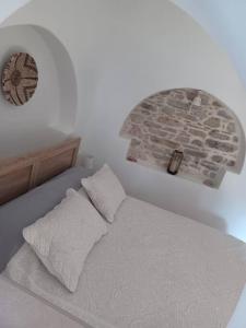 a bed with two pillows in a white bedroom at Nama Seaview Kokkari in Kokkari