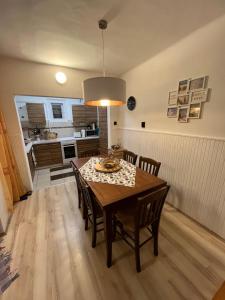 eine Küche und ein Esszimmer mit einem Tisch und Stühlen in der Unterkunft BB Fonyódi út Apartman in Balatonboglár