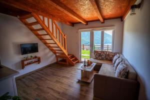 a living room with a couch and a staircase at Guesthouse Madzarevic in Plužine
