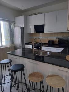 a kitchen with black counter tops and stools at CHEZ LU & LUCIO in Assomada