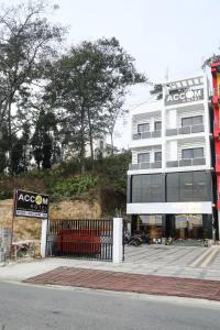 a large white building with a sign in front of it at Accom Hotel in Ilām