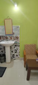 a bathroom with a sink and a chair and a mirror at Laxmi home stay in Ghūra