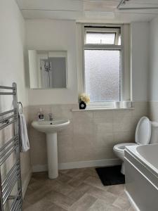 a bathroom with a sink and a toilet and a window at House 36 in Liverpool