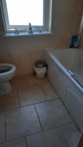 baño con bañera, aseo y ventana en Cobh Rambler en Cobh