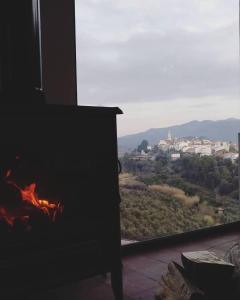 a fireplace in a room with a view of a city at Casa rural Pará de Gaita. Un refugio en la naturaleza in Parcent