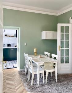 a dining room with a white table and chairs at Medusa Apartment in Krakow