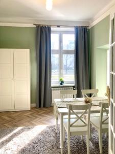 a dining room with a table and chairs and a window at Medusa Apartment in Krakow
