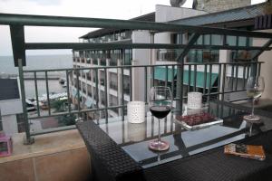 a table with two glasses of wine on a balcony at Cozy studio in Balchik in Balchik