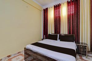 a bedroom with a large bed with red curtains at OYO Flagship The Relax Inn in Lucknow