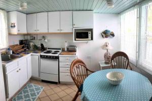 a kitchen with white cabinets and a table and a stove at 12 Sealofts On The Beach - Frigate Bay in Frigate Bay