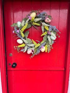 a red door with a christmas wreath on it at Dream Cottage in Ballintober