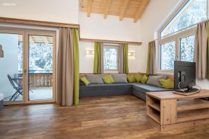 een woonkamer met een bank en een tv bij Appartements Salitererhof in Saalbach Hinterglemm