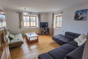 a living room with a couch and a table at Landhaus auf der Alm 