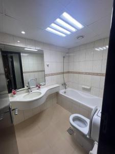 La salle de bains est pourvue d'un lavabo, de toilettes et d'une baignoire. dans l'établissement Cozy 1Bhk with stunning sea view, à Charjah