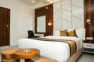 a bedroom with a large bed and a table at Accom Hotel in Ilām