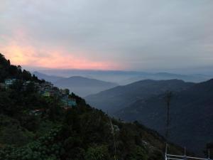 Blick auf einen Berg mit einer Stadt auf einem Hügel in der Unterkunft Rap's Den in Darjeeling