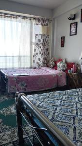 1 Schlafzimmer mit 2 Betten und einem Fenster in der Unterkunft Rap's Den in Darjeeling