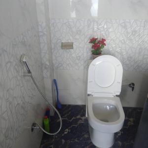 ein Bad mit einem WC und einem Schlauch in der Unterkunft Rap's Den in Darjeeling