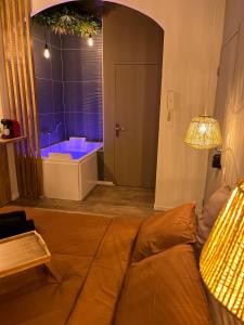 un soggiorno con divano e vasca da bagno di SUITE Serenity Room SPA- Balnéothérapie a Saint-Étienne