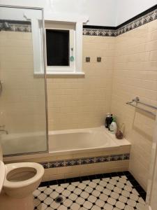 a bathroom with a bath tub and a toilet at Clarence Gardens in Colonel Light Gardens