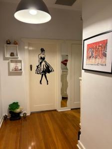 a hallway with a painting of a woman on the wall at Clarence Gardens in Colonel Light Gardens